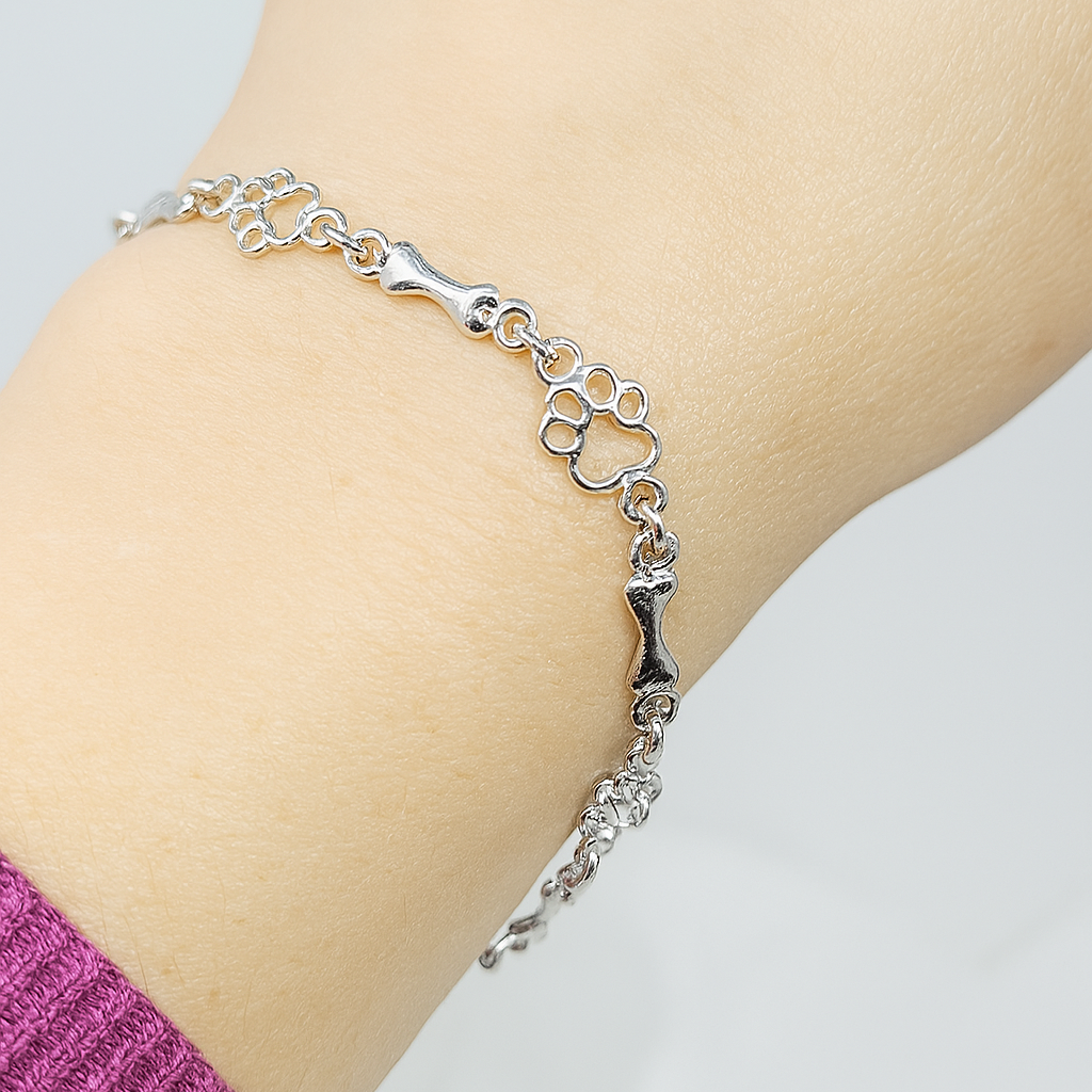 Pulsera con charms de huella y hueso en plata