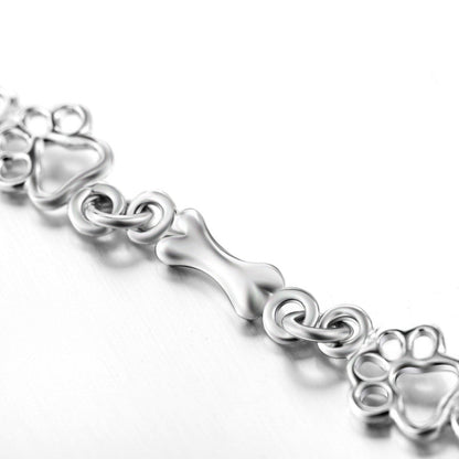 Pulsera con charms de huella y hueso en plata