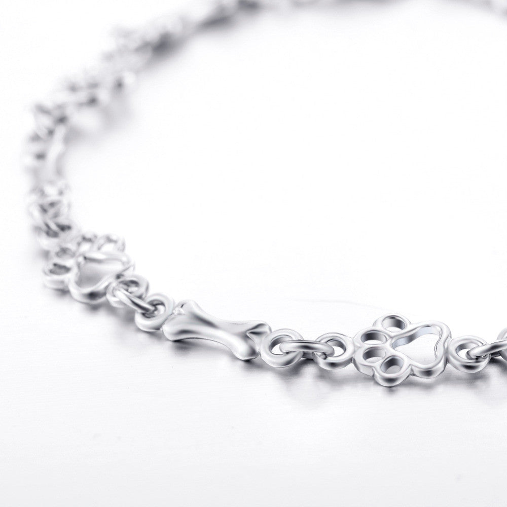 Pulsera con charms de huella y hueso en plata
