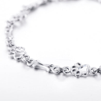 Pulsera con charms de huella y hueso en plata